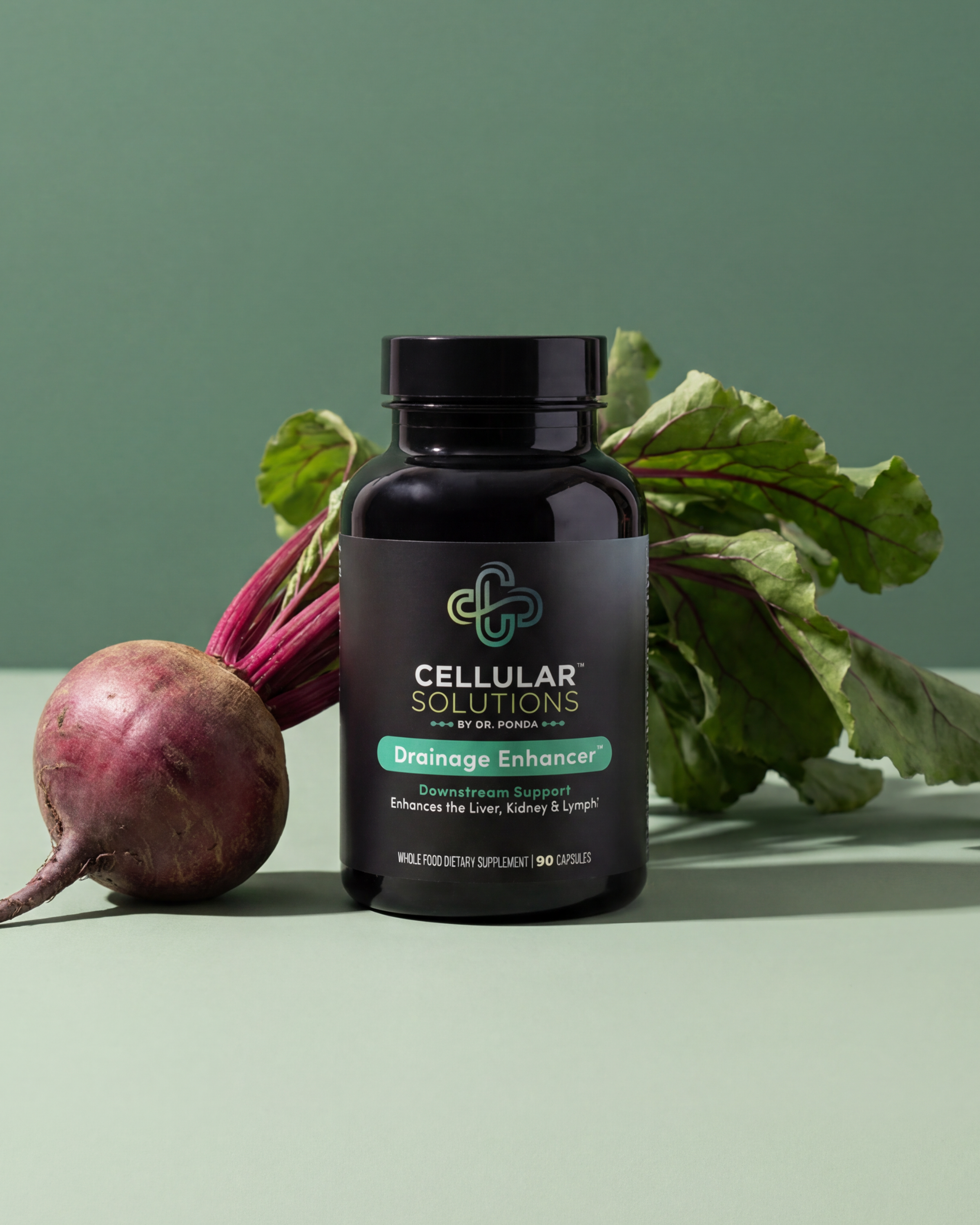 Cellular Solutions Drainage Enhancer bottle on a sage green backdrop with a fresh beet and leafy greens beside it.