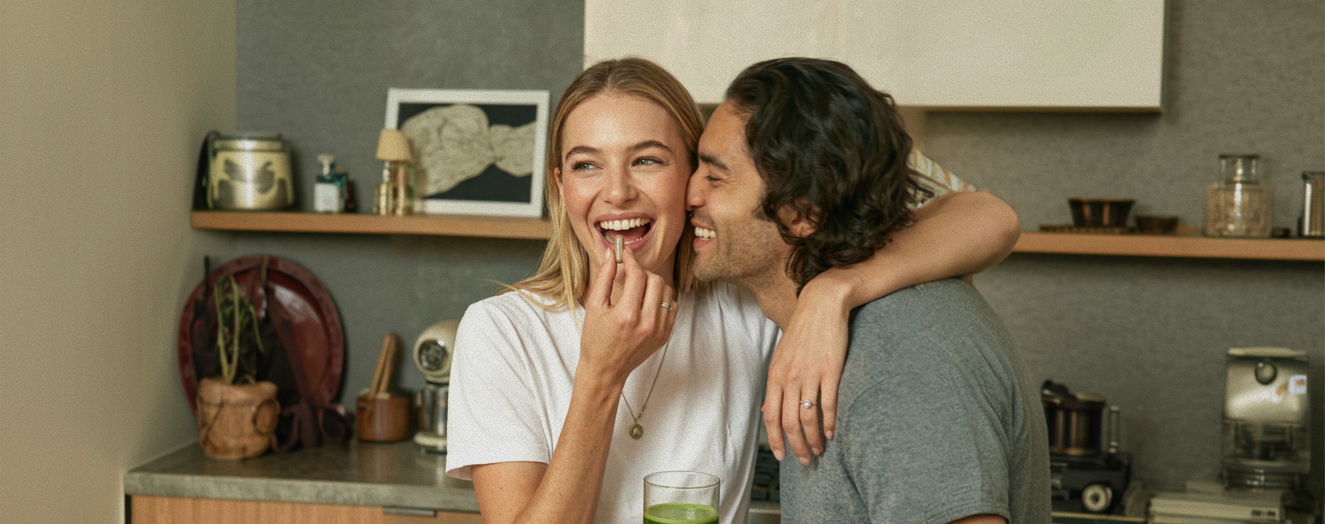 Man and woman embracing in a kitchen, smiling at each other.